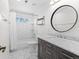 Modern bathroom with a marble vanity, white subway tile, a tub, and a round mirror at 5335 Pecos Way # 4, Denver, CO 80221