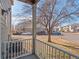 Building exterior featuring a covered porch with white railings and view of the parking area at 5335 Pecos Way # 4, Denver, CO 80221