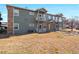 Back exterior of a multi-Gathering building with balconies, green siding, and a manicured lawn at 5335 Pecos Way # 4, Denver, CO 80221