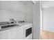 Bright laundry room features a modern washer and dryer, plus overhead storage shelves at 5335 Pecos Way # 4, Denver, CO 80221
