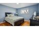 Bedroom with hardwood floors, a queen bed with floral bedding, and light blue painted walls at 3406 E Fair Pl, Centennial, CO 80121