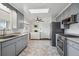 Bright kitchen with stainless steel appliances, gray cabinetry, and herringbone-patterned floors at 3406 E Fair Pl, Centennial, CO 80121