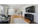 Open-concept living room showcasing hardwood floors, a TV, and seamless transition to the dining area at 3406 E Fair Pl, Centennial, CO 80121