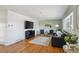 Spacious living room featuring hardwood floors, stylish decor, and a large television for entertainment at 3406 E Fair Pl, Centennial, CO 80121