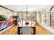 Bright dining room featuring wood floors, an elegant chandelier, and large windows with custom blinds at 566 Monroe St, Denver, CO 80206