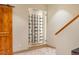 Unique wine cellar with a glass door and wood trim, located near a staircase at 566 Monroe St, Denver, CO 80206