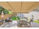 Cozy backyard patio under awning with outdoor furniture, including table, chairs, and sofa at 1382 Braewood Ave, Highlands Ranch, CO 80129