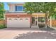 Charming two-story home with a brick facade, attached garage, and mature tree at 1382 Braewood Ave, Highlands Ranch, CO 80129