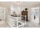 Hallway featuring carpet floors, white railing, and a decorative chandelier at 1382 Braewood Ave, Highlands Ranch, CO 80129