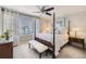 Bright main bedroom features a four-poster bed, ceiling fan, bench, and a sunlit window at 1382 Braewood Ave, Highlands Ranch, CO 80129