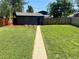 The backyard features well-maintained grass, a wooden fence, and garden plots, creating a serene retreat at 1560 Quince St, Denver, CO 80220