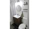 Modern bathroom with wood vanity, round mirror, and sleek black and white accents at 1560 Quince St, Denver, CO 80220