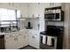 Charming kitchen featuring white cabinets, subway tile backsplash, and stainless steel appliances at 1560 Quince St, Denver, CO 80220