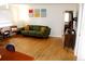 Bright living room featuring hardwood floors, a comfortable green sofa with yellow pillows, and stylish decor at 1560 Quince St, Denver, CO 80220