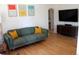 Cozy living room with hardwood floors, comfortable green sofa with yellow pillows, and stylish decor at 1560 Quince St, Denver, CO 80220