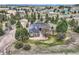 Aerial view of a home nestled among trees, featuring an outbuilding, and fenced perimeter at 3562 Pine Meadow Ave, Parker, CO 80138