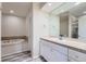 This bathroom features a large soaking tub and a single-sink vanity with a large mirror and drawers at 3562 Pine Meadow Ave, Parker, CO 80138