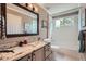 This bathroom features a single-sink granite countertop vanity, a large mirror, and a shower-tub combo at 3562 Pine Meadow Ave, Parker, CO 80138