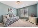 Comfortable bedroom with blue walls, decorative bed, dresser, and natural light coming in from the window at 3562 Pine Meadow Ave, Parker, CO 80138