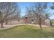 Ranch-style home featuring a well-manicured front lawn, American flag, mature trees, and a charming brick entryway at 3562 Pine Meadow Ave, Parker, CO 80138