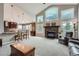 Open living room featuring a fireplace, large windows, and seamless flow to the kitchen with bar seating at 3562 Pine Meadow Ave, Parker, CO 80138