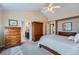 This bright main bedroom provides a view into the on-suite bathroom, plenty of closet and dresser storage, and ceiling fan at 3562 Pine Meadow Ave, Parker, CO 80138