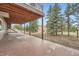 Outdoor patio with covered area, surrounded by green trees and grassy area at 3562 Pine Meadow Ave, Parker, CO 80138