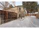 Snowy backyard with wooden fence and pathway at 3742 S Danube Cir, Aurora, CO 80013