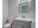 Small bathroom with a gray vanity, white sink, and a toilet at 3742 S Danube Cir, Aurora, CO 80013