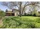 Spacious backyard with manicured lawn, mature trees, a covered patio, and exterior of home at 10886 E Berry Ave, Englewood, CO 80111
