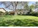 Expansive backyard with lush lawn and mature trees that surround the home at 10886 E Berry Ave, Englewood, CO 80111