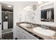 Bright bathroom featuring double sinks, a walk-in closet, and a glass door shower at 10886 E Berry Ave, Englewood, CO 80111