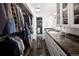 Bright bathroom featuring marble floors, shower, closet, double sink, and vanity at 10886 E Berry Ave, Englewood, CO 80111