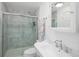 Bright bathroom with white marble tile, vanity, and a glass door shower at 10886 E Berry Ave, Englewood, CO 80111
