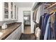 Bathroom with a walk-in closet, double sink vanity, and dark marble countertops at 10886 E Berry Ave, Englewood, CO 80111