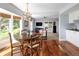 Breakfast nook area with round wooden table and wood frame chairs with hardwood flooring and views to the backyard at 10886 E Berry Ave, Englewood, CO 80111