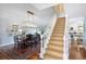 Elegant dining area with modern light fixture, table with seating, and staircase view at 10886 E Berry Ave, Englewood, CO 80111