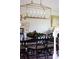 Close up of dining room table with floral centerpiece and ornate black chairs under a modern chandelier at 10886 E Berry Ave, Englewood, CO 80111