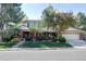 Traditional two-story home with well-maintained lawn and mature trees on a sunny day at 10886 E Berry Ave, Englewood, CO 80111