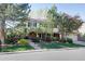 Traditional two-story home with well-maintained lawn and mature trees on a sunny day at 10886 E Berry Ave, Englewood, CO 80111