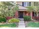 Charming brick home features a welcoming front door adorned with a colorful wreath at 10886 E Berry Ave, Englewood, CO 80111