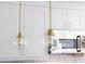 Charming kitchen showcasing globe pendant lights, white cabinets, and subway tile backsplash at 10886 E Berry Ave, Englewood, CO 80111