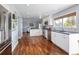 Modern kitchen featuring stainless steel appliances, white cabinetry, and beautiful hardwood floors at 10886 E Berry Ave, Englewood, CO 80111