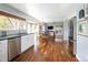 Bright eat-in kitchen with stainless steel appliances, white cabinetry, hardwood floors, and natural light at 10886 E Berry Ave, Englewood, CO 80111