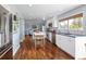 Modern kitchen featuring stainless steel appliances, white cabinetry, and beautiful hardwood floors at 10886 E Berry Ave, Englewood, CO 80111