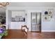 Bright eat-in kitchen with stainless steel refrigerator, subway tile backsplash, and hardwood floors at 10886 E Berry Ave, Englewood, CO 80111