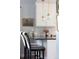 Kitchen counter with barstool seating under pendant lighting, with white cabinets and gray subway tile backsplash at 10886 E Berry Ave, Englewood, CO 80111
