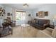 Cozy living room with an eclectic mix of chairs and a sofa surrounding a glass coffee table and a large window at 10886 E Berry Ave, Englewood, CO 80111
