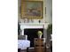Living room fireplace with decorative mantle, flowers, artwork and comfortable seating in the foreground at 10886 E Berry Ave, Englewood, CO 80111