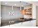 Stylish bar area with a dark countertop, custom wine rack, and modern pendant lighting at 13325 W 86Th Dr, Arvada, CO 80005